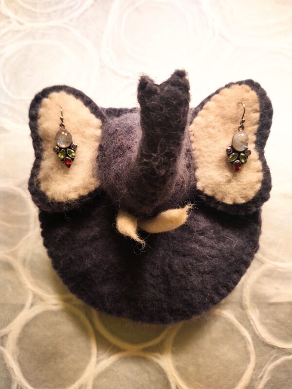 A Stuffed Elephant Toy with Bejeweled Earrings on Both Ears